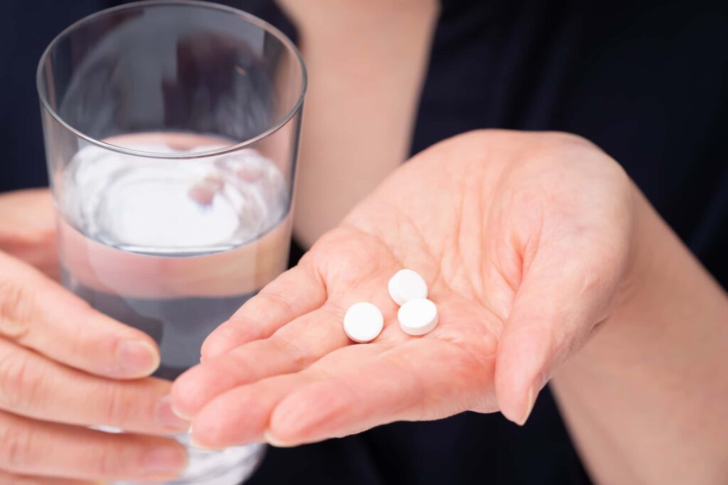インプラント治療の痛みを抑える為に鎮痛剤を飲むイメージ