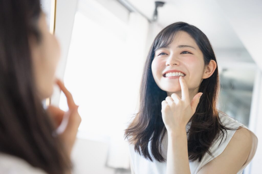 虫歯・歯周病を予防するためにセルフチェックを行う女性